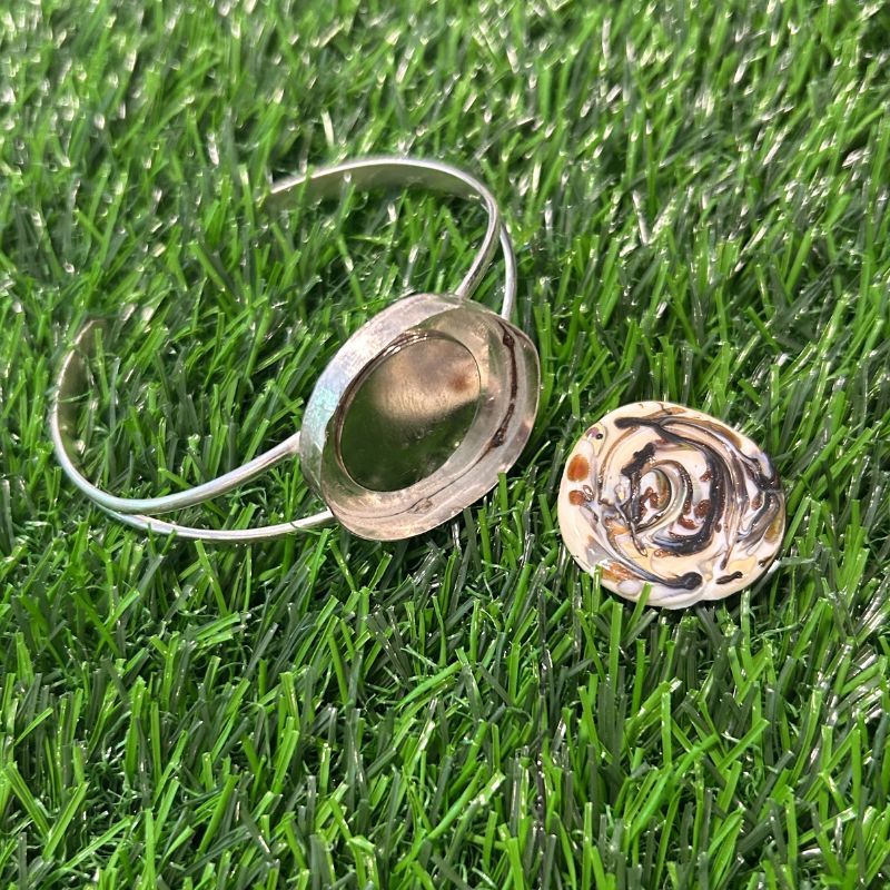 Ball Marker Wide Split Bracelet on grass shows how the unique 25mm glass ball marker stays in place with the magnet in the 27mm bezel